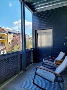 uma varanda com duas cadeiras num edifício azul em Gemütliche Stadtwohnung in Klagenfurt em Klagenfurt