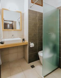 a bathroom with a sink toilet and a mirror at Apollo Resort in Agia Marina Aegina