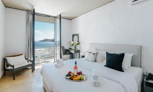 a bedroom with a white bed with a view of the ocean at Apollo Resort in Agia Marina Aegina