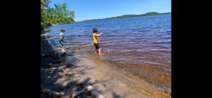 dos personas están de pie en el agua en la playa en Le Péribonka en LʼAscension