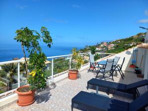 einen Balkon mit Stühlen und Meerblick in der Unterkunft Casa Dos Ramos in Arco da Calheta