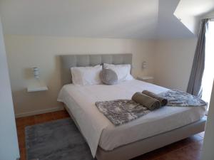 a bedroom with a large bed with two pillows at Casa Dos Ramos in Arco da Calheta