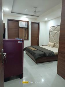 um quarto com uma cama e uma televisão em OYO Hotel Daffodils Near Aravali Biodiversity Park em Gurgaon
