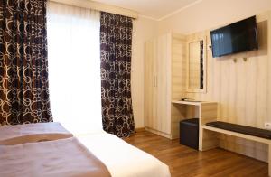 a hotel room with a bed and a flat screen tv at La Hacienda in Ulcinj