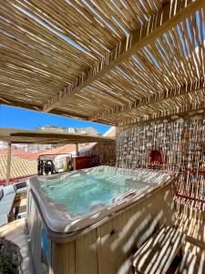 a hot tub on a deck with a pergola at PortaDelMare deluxe suites in Hydra