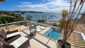 a balcony with a view of the water and boats at Pousada Ao Por do Sol in Búzios