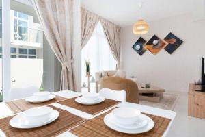 a dining room with a table with white dishes on it at Calm Aesthetic 3 Bedroom Villa - E&G Homes in Dubai