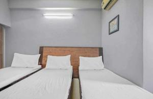 Habitación pequeña con 2 camas y paredes blancas. en OYO Hotel Travel INN en Nueva Delhi