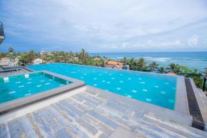 a swimming pool with the ocean in the background at Somerset Mirissa Blue in Mirissa