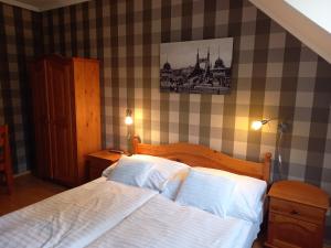 a bedroom with a bed with white sheets and pillows at Európa Panzió in Eger