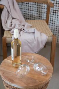 eine Flasche Öl und Gläser auf einem Holztisch in der Unterkunft Sunlight in Kamarai