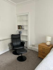 a bedroom with a black chair and a bed at Stylish 2nd Floor Georgian 1 Bedroom Apartment in Dumfries