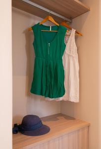 un vestido verde y un sombrero en un estante en Sunlight, en Kamarai