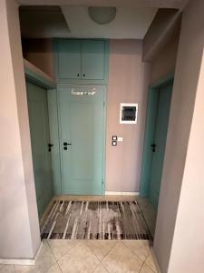 un couloir avec des portes vertes et un tapis dans l'établissement Happy Colors House Xanthi, à Xánthi