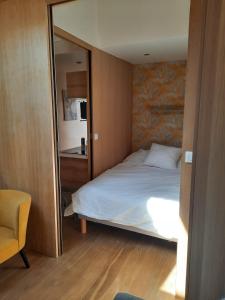 een slaapkamer met een bed en een grote spiegel bij Renovated fully equipped studio for 2 to 4 pers in La Ciotat