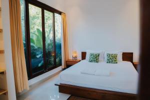 a bedroom with a bed and a large window at Villa Gading 2 in Ubud