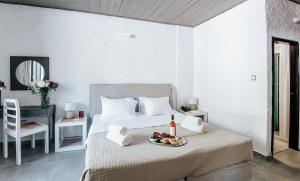 a bedroom with a bed with a tray of fruit on it at Apollo Resort in Agia Marina Aegina