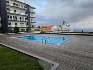 une piscine en face d'un bâtiment dans l'établissement Penthouse Quinta Village Garajau, à Caniço
