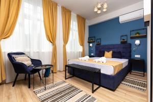 a blue bedroom with a bed and a chair at Kapana Guest House on Central Pedestrian street with Parking included in Plovdiv