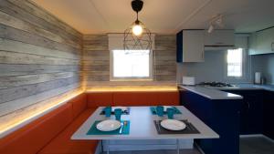 a small kitchen with a table with plates on it at Somo Bungalow Resort - Camping Latas in Somo