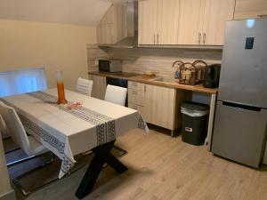 a kitchen with a table and a refrigerator at Comme à la Maison in Brussels