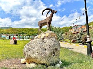 une statue de chèvre au sommet d'une roche dans l'établissement Deluxe Park Qusar Resort & Spa Hotel, à Qusar