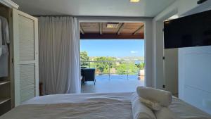 a bedroom with a bed and a view of a patio at Pousada Ao Por do Sol in Búzios +162 photos