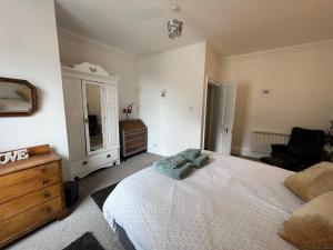 a bedroom with a large white bed and a dresser at Stylish 2nd Floor Georgian 1 Bedroom Apartment in Dumfries