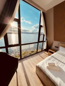 a bedroom with a large window overlooking the ocean at Noy Land Resort in Sevan