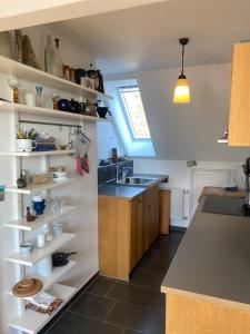 a kitchen with a sink and a counter with shelves at Nolte Faarderhuuch 7 in Norddorf