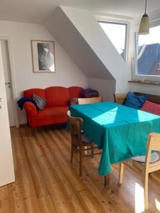 a living room with a table and a red couch at Nolte Faarderhuuch 7 in Norddorf