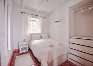 um quarto branco com uma cama e uma janela em CASA do PÁTIO em Faja Grande
