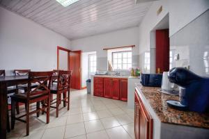 a kitchen with a table and chairs and a counter top at CASA do PÁTIO in Faja Grande