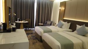 a hotel room with two beds and a table at H Luxury Hotel in Wadi Musa