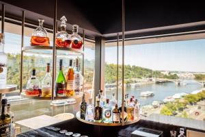 a bar with bottles of alcohol and a view of a river at The President in Prague