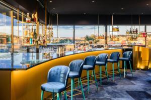 a bar with blue chairs and a view of the city at The President in Prague