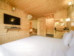 1 dormitorio con 1 cama y TV en la pared en Hotel Mirage, en Srinagar