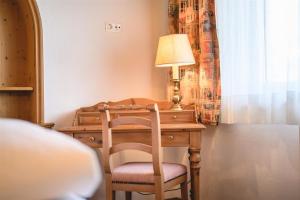 einen Schreibtisch mit einer Lampe und einem Stuhl in einem Zimmer in der Unterkunft Haus Barbarahof in Altenmarkt im Pongau