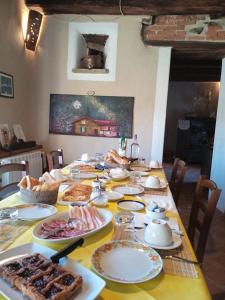 una mesa llena de comida en una mesa amarilla en Cascina Boschetto, en Saliceto