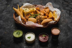 a basket of food with a basket of fries and dips at Capital O Del Inn in New Delhi