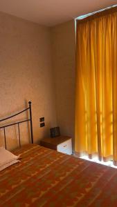 a bedroom with a bed and a yellow curtain at Caravaggio Apartments in Bergamo