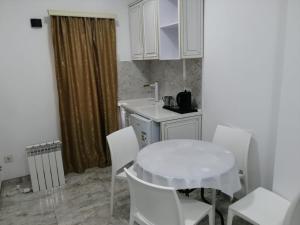 uma cozinha com uma mesa branca e cadeiras brancas em Гостьовий будинок Східна 19 em Umanʼ