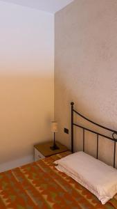 ベルガモにあるCaravaggio Apartmentsのベッドルーム1室(ベッド1台、テーブルの上にランプ付)
