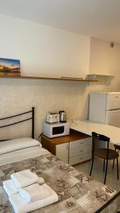 Habitación con cama y cocina con microondas. en Caravaggio Apartments, en Bérgamo