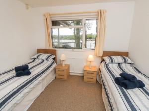 two twin beds in a room with a window at Byewater in Ryde