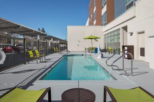 a swimming pool with tables and chairs on a building at SpringHill Suites by Marriott West Sacramento in West Sacramento