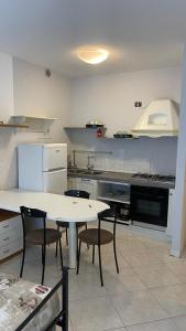 una cocina con mesa blanca y sillas. en Caravaggio Apartments, en Bérgamo