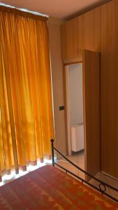 Habitación con cortina de color naranja y escalera en Caravaggio Apartments, en Bérgamo