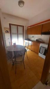 eine Küche mit einem Tisch und Stühlen im Zimmer in der Unterkunft Alloggio Open Space. in Alba Adriatica