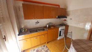 eine kleine Küche mit Holzschränken und einem Waschbecken in der Unterkunft Alloggio Open Space. in Alba Adriatica